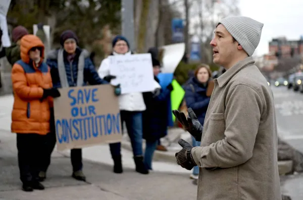 A picture of President Lewis speaking to a rally protesting the billionaire takeover of our federal government. Location in State College at the Allen St. Gates.